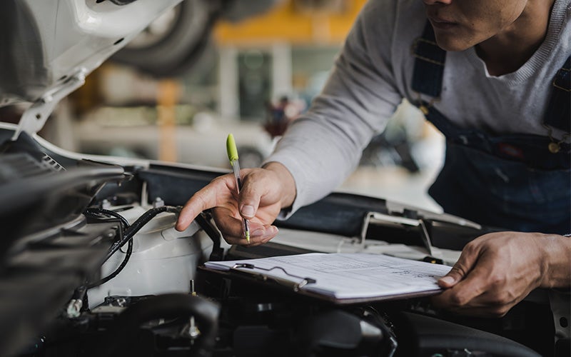 Photo of a mechanic inspecting a vehicle